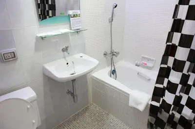 a bathroom with a sink and a toilet and a bath tub at PR Place Hotel in Bangkok