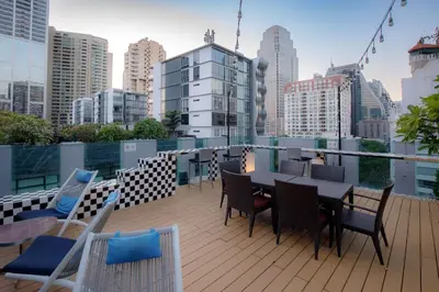 a balcony with a table and chairs on a building at Park Plaza Bangkok Soi 18 in Bangkok