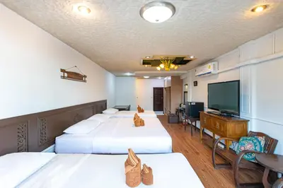 a hotel room with two beds and a flat screen tv at SK Boutique Mahanakhon in Bangkok