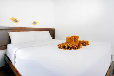a white bed with brown mittens and towels on it at SK Boutique Mahanakhon in Bangkok