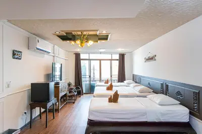 a hotel room with four beds and a flat screen tv at SK Boutique Mahanakhon in Bangkok