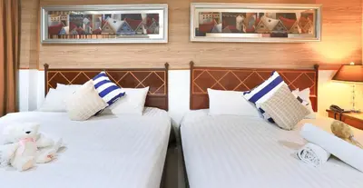 two beds with stuffed animals on them in a room at Diamond City Hotel SHA Certified in Bangkok