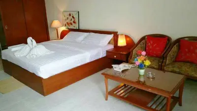 a hotel room with a bed and a coffee table at Poonchock Mansion in Bangkok