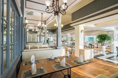 a dining room with tables and a restaurant at Kalanan Riverside Resort in Nonthaburi