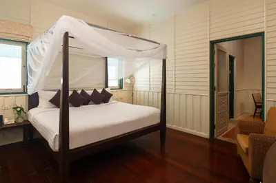 a bedroom with a bed with a canopy at Kalanan Riverside Resort in Nonthaburi