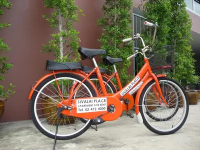 an orange bike parked next to a building at Sivalai Place in Bangkok