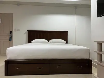 a bed with two pillows on it in a bedroom at Mall Suites Hotel in Bangkok