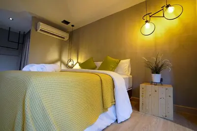 a bedroom with a bed with a yellow and white blanket at Hap@sathorn in Bangkok
