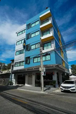 a blue building with a car parked in front of it at Hap@sathorn in Bangkok