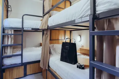 a room with two bunk beds and a bag at Peace Factory Hostel in Bangkok