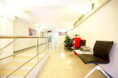 a hallway with two chairs and a stair case at Smile Inn in Bangkok