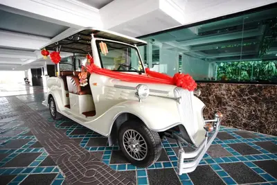 a white golf cart with red bows in a building at Romance Hotel Sukhumvit 97 in Bangkok
