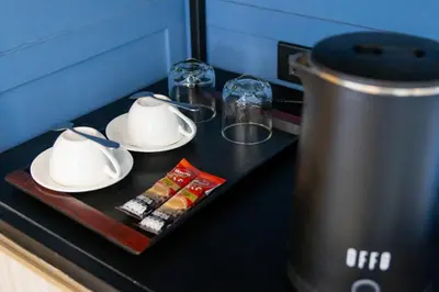 a table with two cups and plates and a tea kettle at Penpark Place in Bangkok