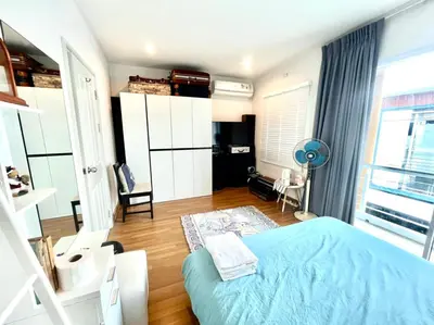 a bedroom with a blue bed and a large window at Autta house in Ban Lat Tanot
