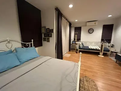 a bedroom with a bed and a living room at Autta house in Ban Lat Tanot
