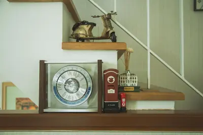 a clock on a shelf next to a staircase at Autta house in Ban Lat Tanot