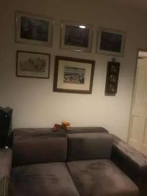 a living room with a couch and pictures on the wall at Autta house in Ban Lat Tanot