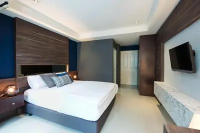 a bedroom with a large bed and a flat screen tv at NW Apartment Lasalle 59 in Bangna