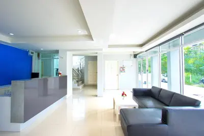 a living room with a couch and some windows at NW Apartment Lasalle 59 in Bangna