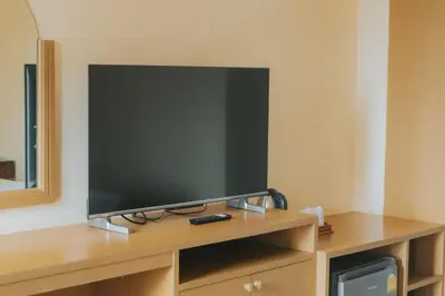 a flat screen tv sitting on top of a wooden entertainment center at Nonthaburi Palace Hotel in Nonthaburi
