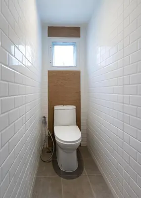 a bathroom with a toilet with a window at Siam Star Hotel in Bangkok