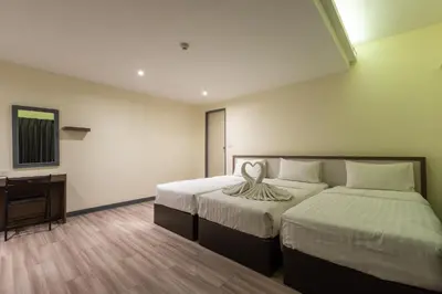 a hotel room with two beds and a desk at Siam Star Hotel in Bangkok