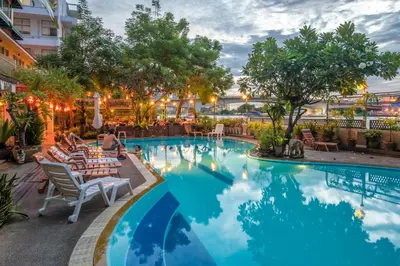 a pool at a hotel with chairs and trees at New Siam Riverside in Bangkok
