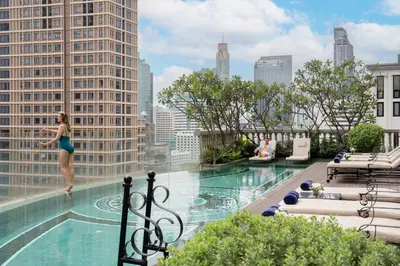 a woman standing on the edge of a pool on a building at Hotel Muse Bangkok, Autograph Collection by Marriott in Bangkok