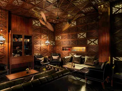 a room with leather chairs and tables and a bar at Hotel Muse Bangkok, Autograph Collection by Marriott in Bangkok