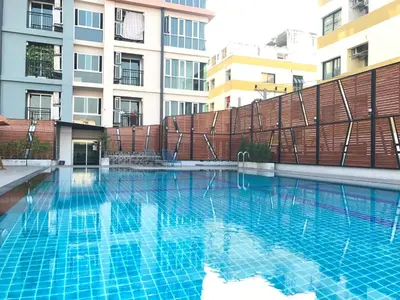 a swimming pool in front of a building at Central Mansion in Bangkok