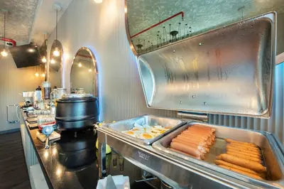 a restaurant kitchen with a tray of food on a counter at Qiu Hotel Sukhumvit - BTS On Nut Station in Bangkok