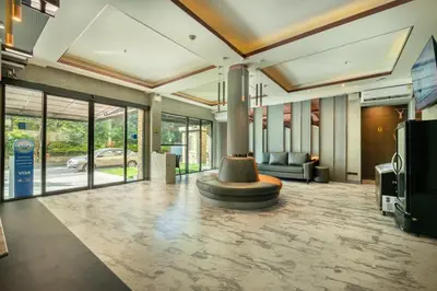 a lobby with a couch and a fountain in the middle at Qiu Hotel Sukhumvit - BTS On Nut Station in Bangkok