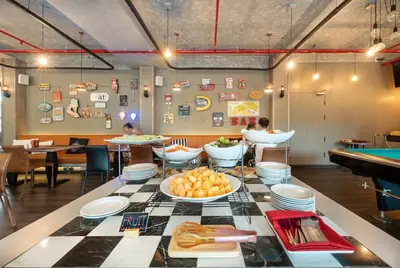a restaurant with a table with plates of food at Qiu Hotel Sukhumvit - BTS On Nut Station in Bangkok