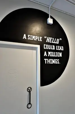 a sign on a door that says a smile could lead a million things at Bedspread Hostel in Bangkok