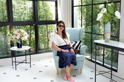 a woman sitting in a chair in a room with windows at Bedspread Hostel in Bangkok