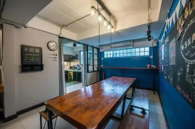 a dining room with a wooden table and a chalkboard at 4SHARE Hostel in Bangkok