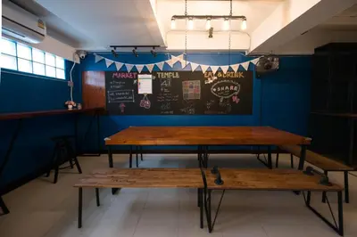 two tables in a room with a chalkboard on the wall at 4SHARE Hostel in Bangkok