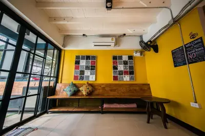 a bench in a room with yellow walls at 4SHARE Hostel in Bangkok