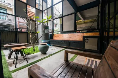 a room with a bench and a potted plant at 4SHARE Hostel in Bangkok