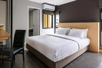 a bedroom with a bed and a desk and a chair at Travelier Hostel in Bangkok