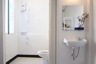 a white bathroom with a toilet and a sink at 12/14 HOME Studio in Bangkok