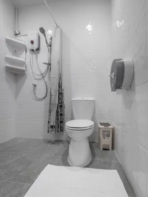 a bathroom with a toilet and a phone on the wall at Tiny Taladnoi Hostel in Bangkok