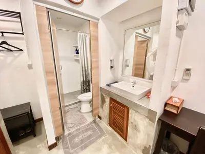 a bathroom with a sink and a toilet and a mirror at Tiny Taladnoi Hostel in Bangkok