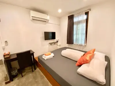 a small room with a bed and a television at Tiny Taladnoi Hostel in Bangkok