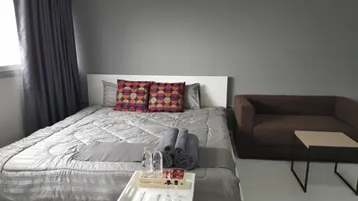 a bedroom with a bed and a chair at Popular Condo C5 IMPACT in Pak Kret