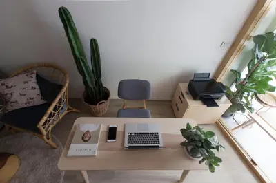 a living room with a table with a laptop computer on it at Pinto Hostel in Bangkok