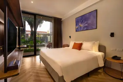 a bedroom with a large bed and a television at Red Door Samsen Hotel, Bangkok in Bangkok