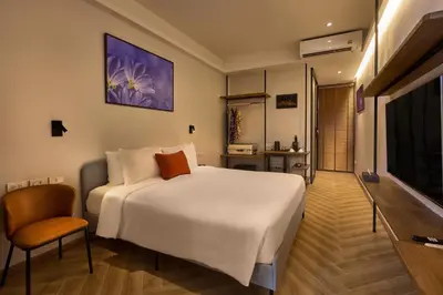 a bedroom with a large white bed and a television at Red Door Samsen Hotel, Bangkok in Bangkok