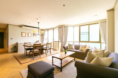 a living room with a couch and a table at THEA Private Suites by TH District in Bangkok