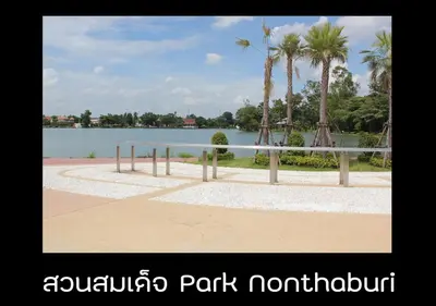 a tennis court in front of a lake with palm trees at New Room in Nonthaburi